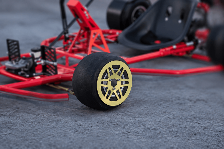 Red drift kart on track. The wheel and the gold rim are on focus 